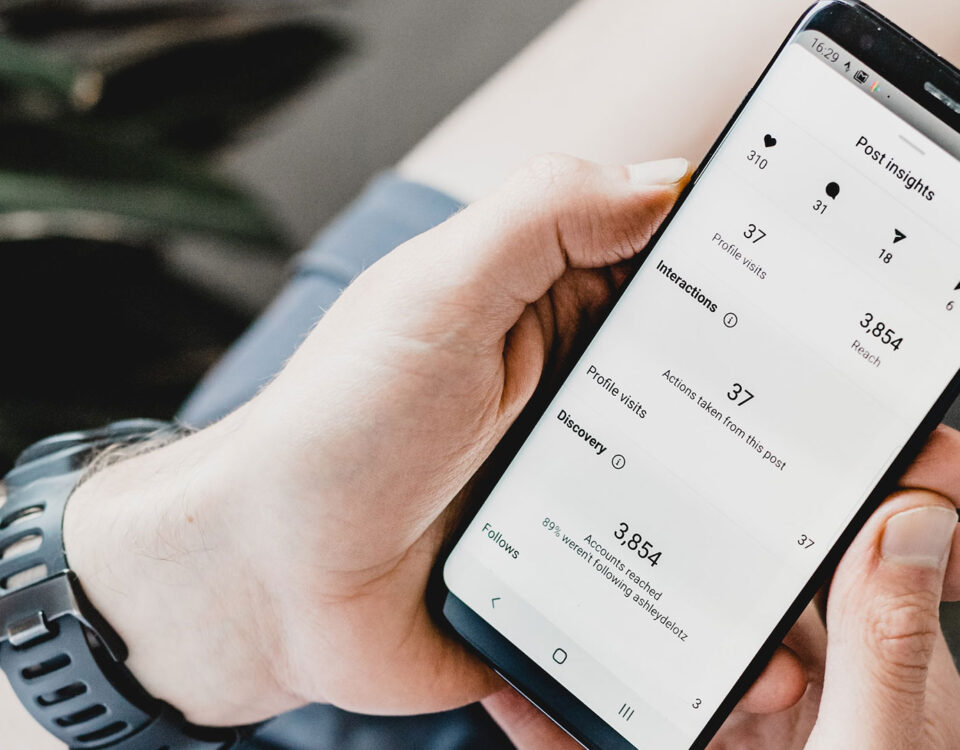 Man holding phone that shows Instagram metrics.