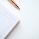 Yearly planner book sitting on a white table with a pen.